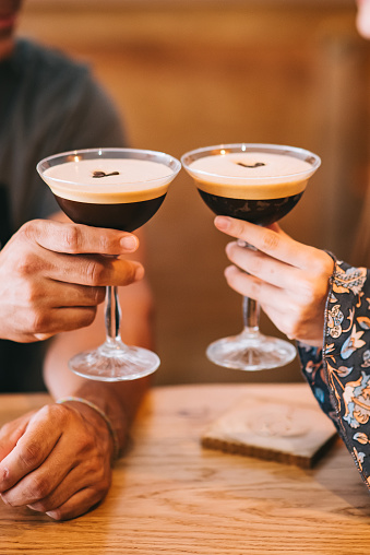 Two servings of espresso coffee cocktail in tall martini glasses decorated with coffee beans