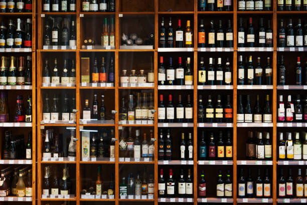 A large wooden cabinet filled with many different kinds of bottles of wine at a supermarket.
